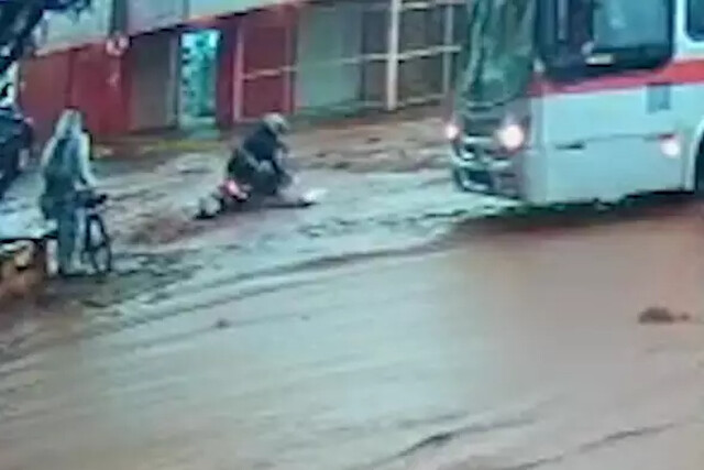 Mulher cai de moto durante enxurrada ao ser pressionada por motorista de ônibus